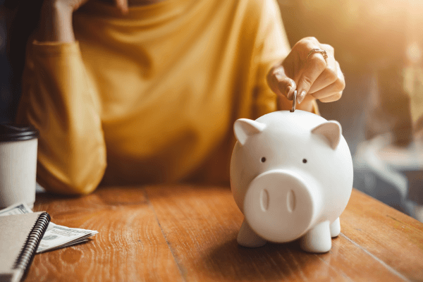 Person depositing money in a piggy bank