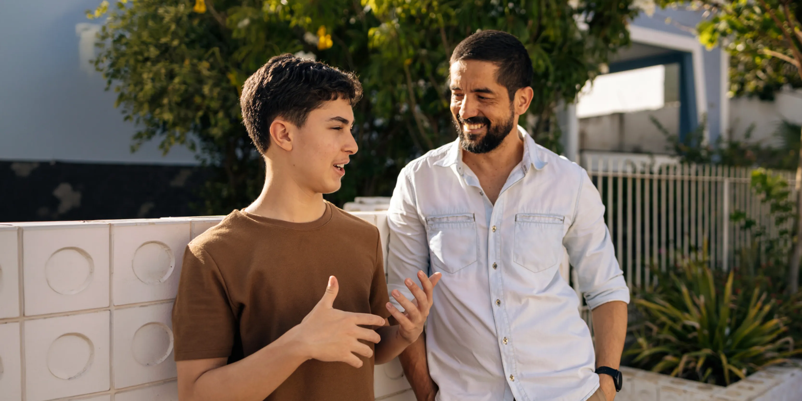 Helping Your Kids Make the Most of Their Summer Money: Father and son talking outside