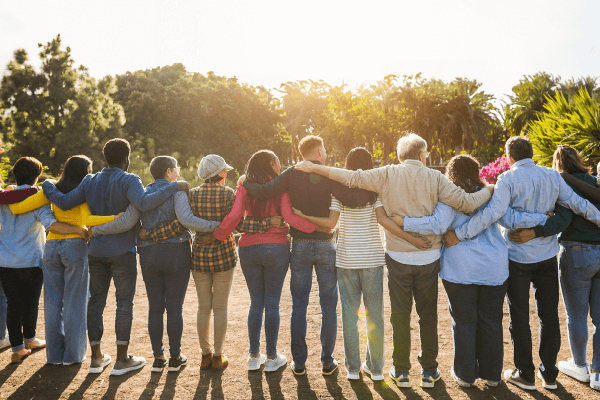 A large group of people with arms around each other