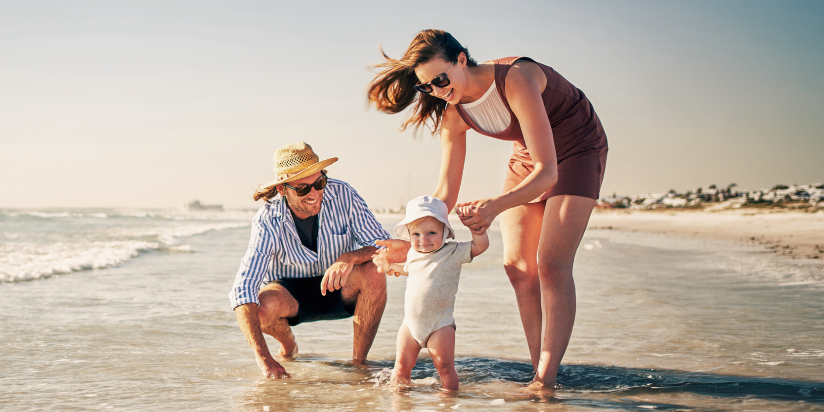 Mother, father and baby on the beach