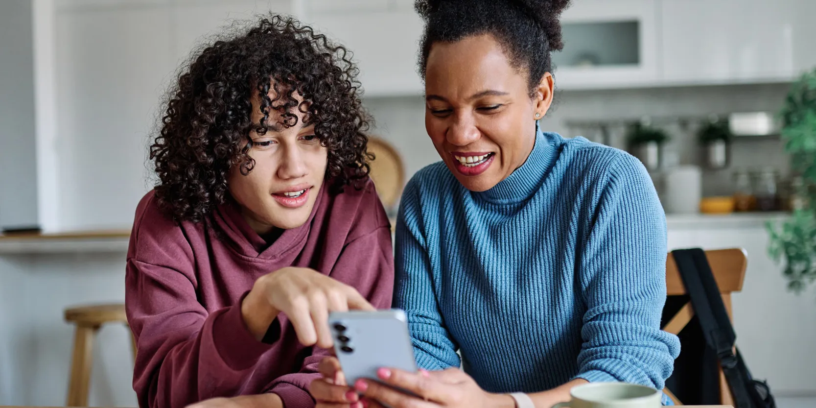 How Much Money Should Kids Have in their Account - Mother and child looking at a phone